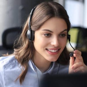 A customer service representation women wearing her headphone and making an outbound call